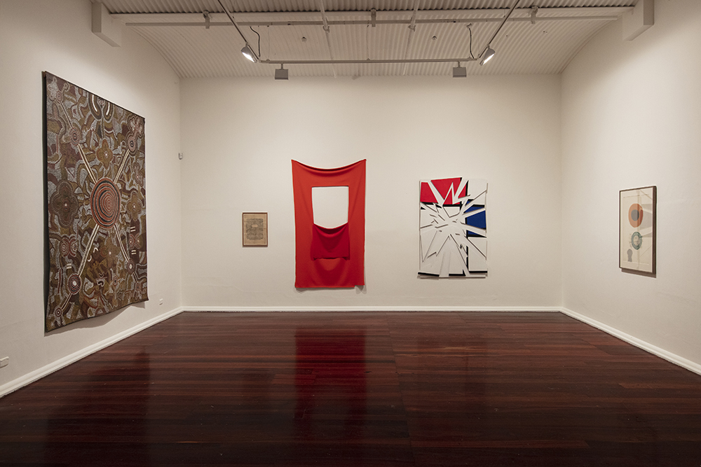 installation view: Agatha Gothe-Snape with Cruthers Collection of Women's Art - Trying to find comfort in an uncomfortable chair, Perth Institute of Contemporary Art, Perth, 2019, showing left to right : Lily Napanangka & Peter Talbot Jupurrula, Ngalkirdi Tjukurpa (Witchetty Grub Dreaming), 1985, Michelle Nikou, Spread Box, 2005, Elizabeth Newman, Untitled, 2005, Maria Kozic, Master Pieces (Mondrian), 1986, Janet Dawson, Montant (Rising), 1960