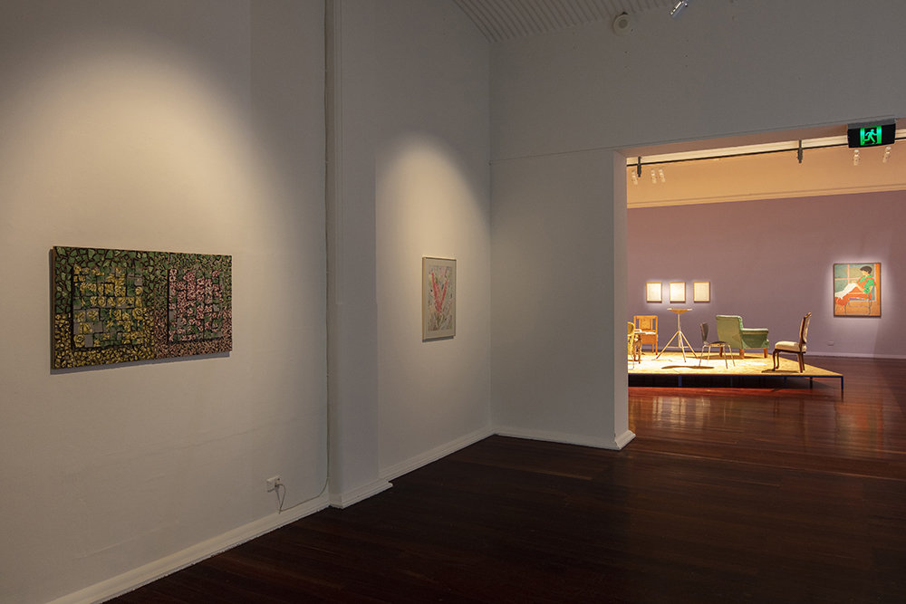 installation view: Agatha Gothe-Snape with Cruthers Collection of Women's Art - Trying to find comfort in an uncomfortable chair, Perth Institute of Contemporary Art, Perth, 2019, showing left to right on wall: Rosalie Gascoigne, A Rose is a Rose, 1986 – 88, Miriam Stannage, Hakea in Landscape, c. 1984; background platform: Agatha Gothe-Snape, Trying to find comfort in an uncomfortable chair, 2019; left to right on background wall: Agatha Gothe-Snape, Giles Hohnen