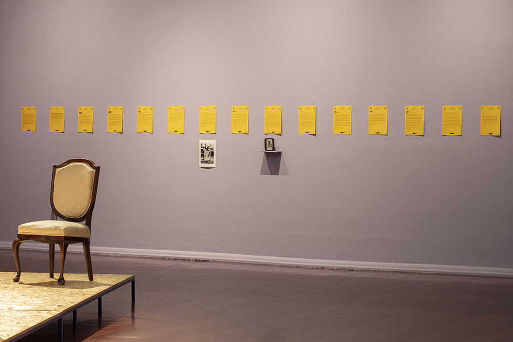 installation view: Agatha Gothe-Snape with Cruthers Collection of Women's Art - Trying to find comfort in an uncomfortable chair, Perth Institute of Contemporary Art, Perth, 2019, showing on platform: Agatha Gothe-Snape, Trying to find comfort in an uncomfortable chair, 2019; top on wall: Agatha Gothe-Snape, 14 letters requesting the loan of chairs sent April 2019; bottom on wall, left to right: Helen Eager, Chair - Unfinished business, 1975-, Narelle Jubelin, Series 7 chair by Arne Jacobsen, 2019